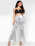 Smiling model wearing white sequin bell bottoms with flared hem