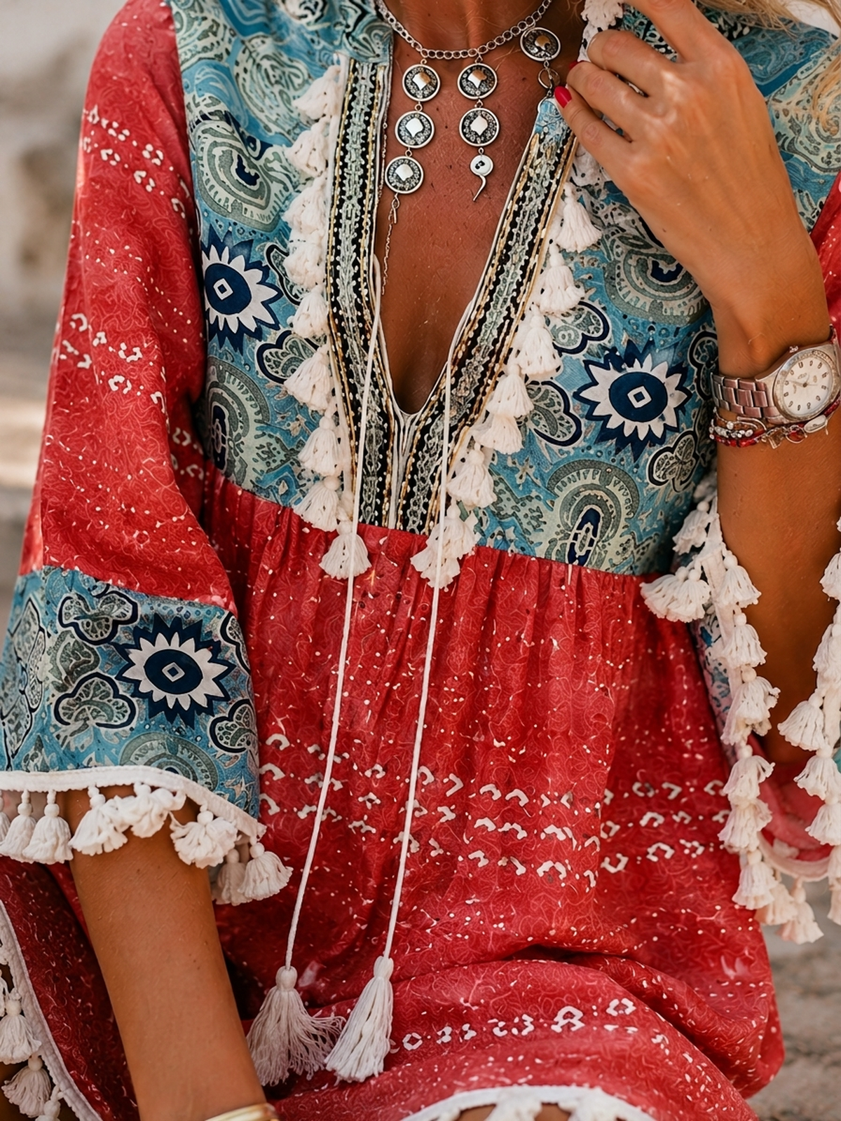 Detail of the laced V-neck pompoms and terracotta patchwork print