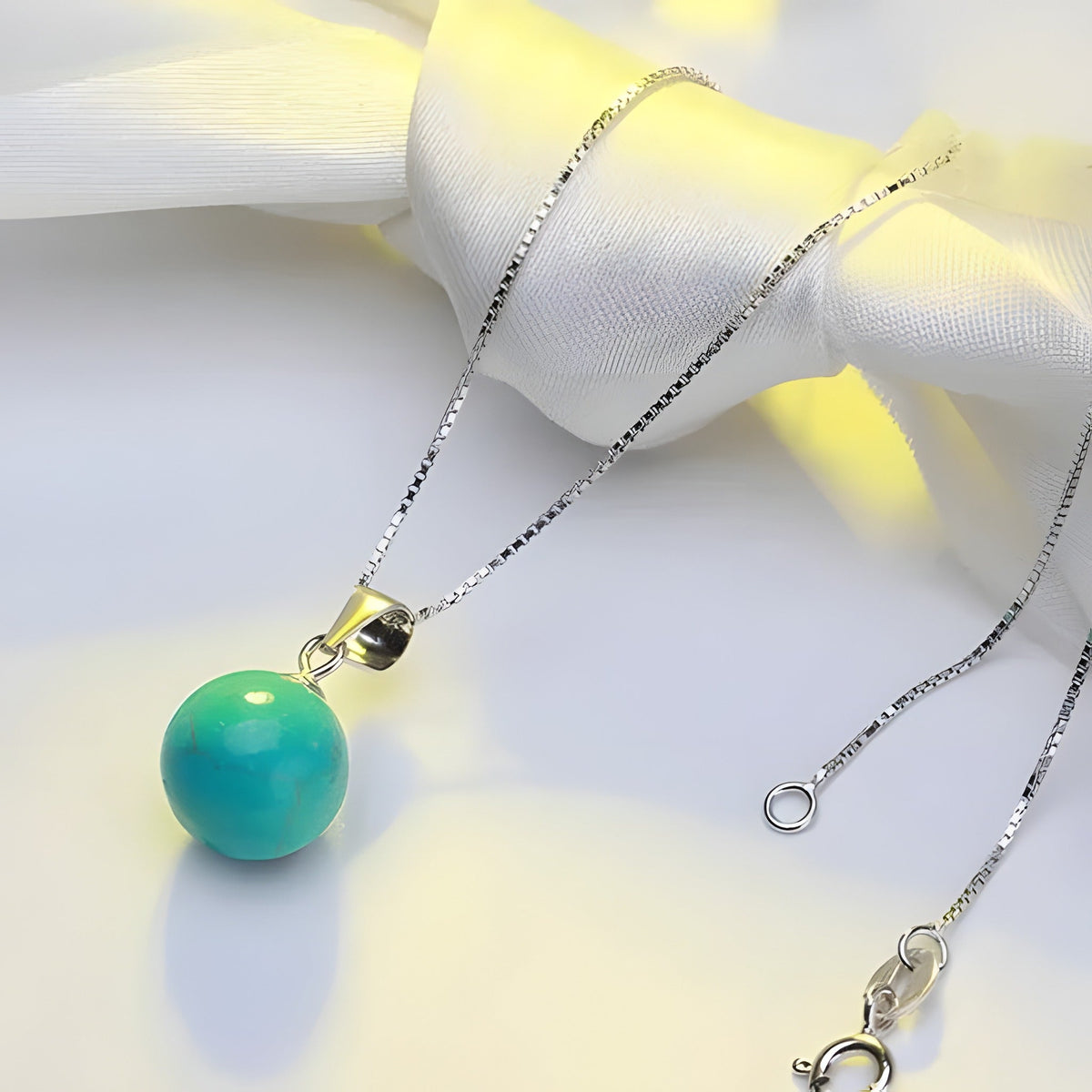 Close-up of the turquoise pendant and clasp on satin
